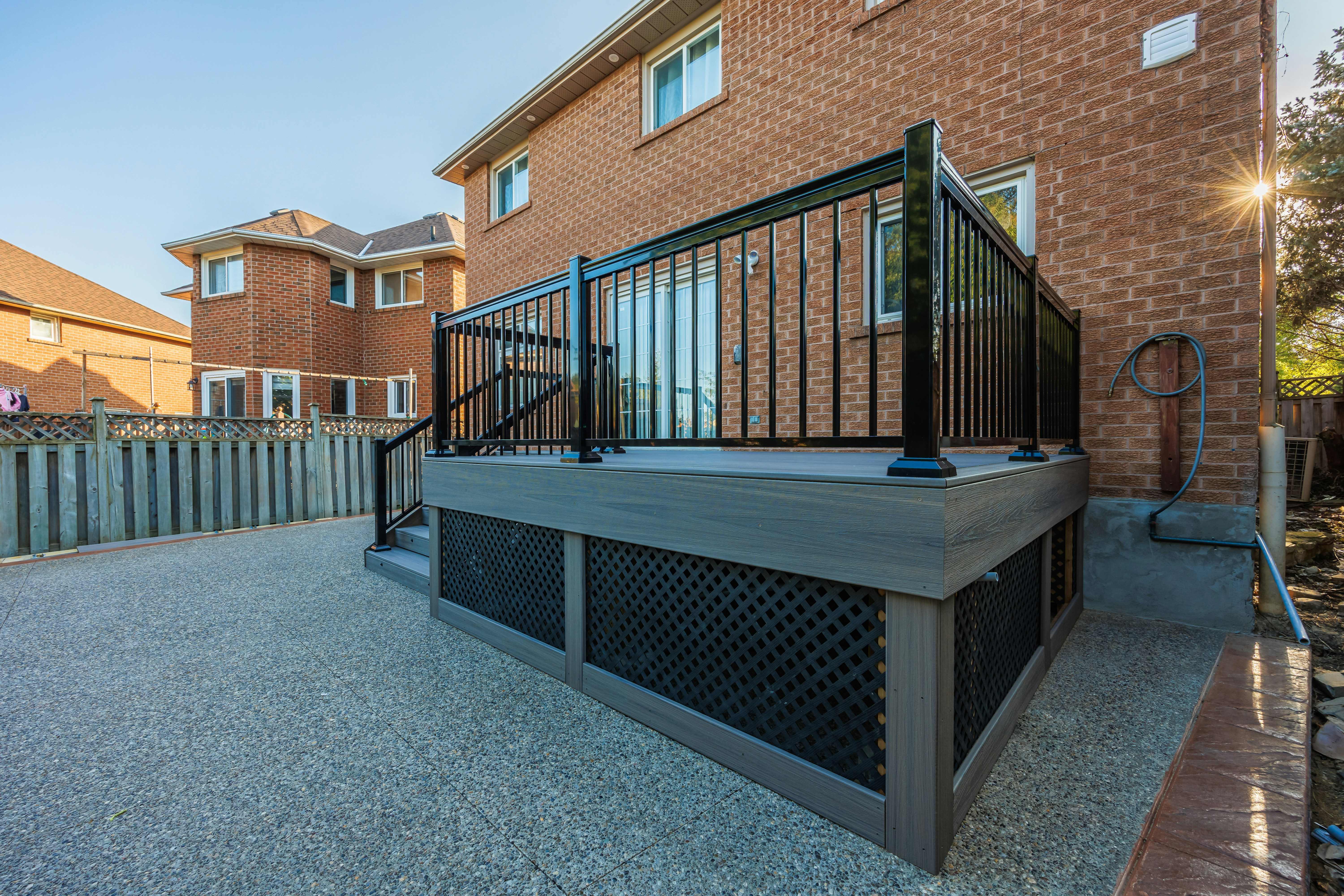 Modern elevated composite deck with black metal railings and professional lattice skirting