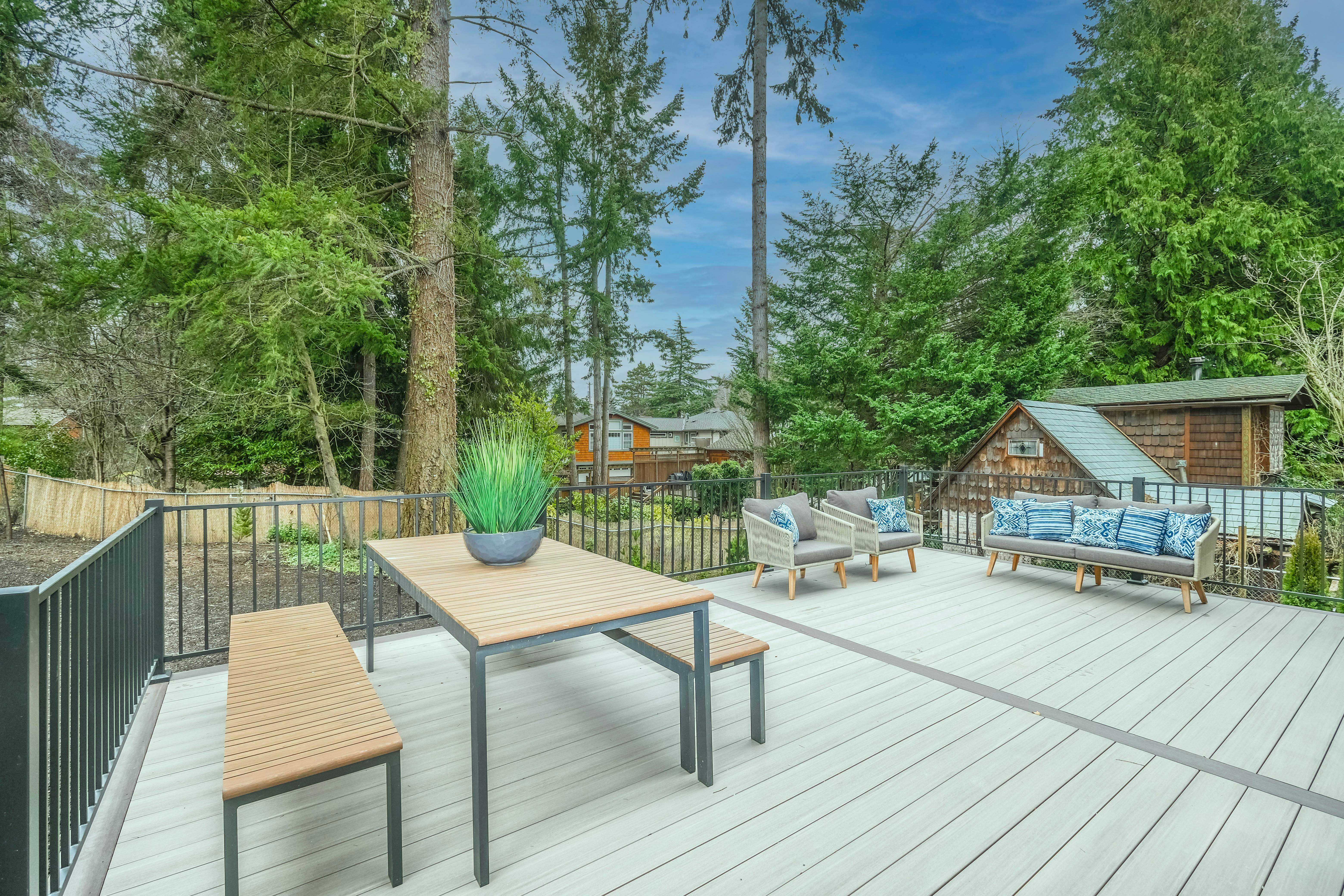 Contemporary outdoor deck with dining area and comfortable seating featuring blue cushions